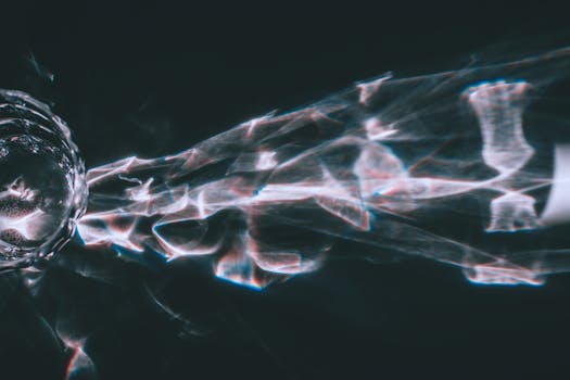 Artistic abstract light refraction through glass creating a dazzling visual effect on a dark surface.