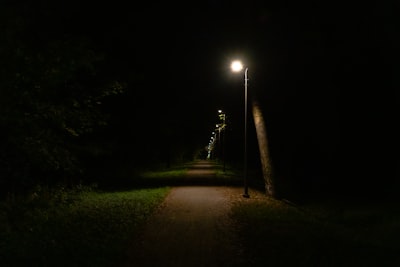 A street light on a dark street at night